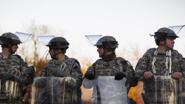 Bracing for trouble: National Guard soldiers stand in formation outside the Ferguson Police Department.