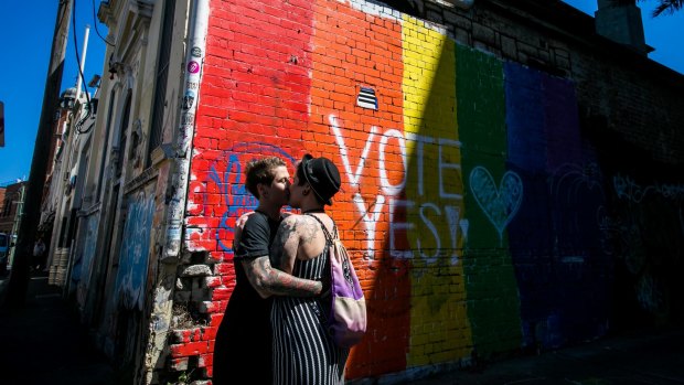  A couple embrace to celebrate the "yes" verdict of Australia's postal vote on same-sex marriage in Newtown.