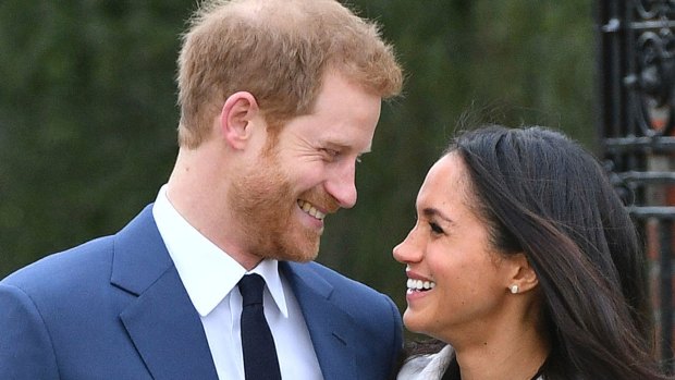 Britain's Prince Harry and Meghan Markle smile as they pose for the media in the grounds of Kensington Palace .