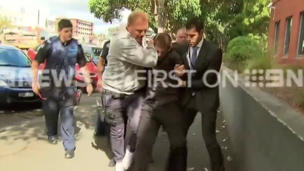 Bradley John Azzopardi puts up a fight on his way into court.