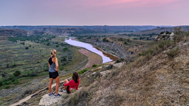 Hiking escarpments with layers of ancient, pastel-hued rocks near Medora.