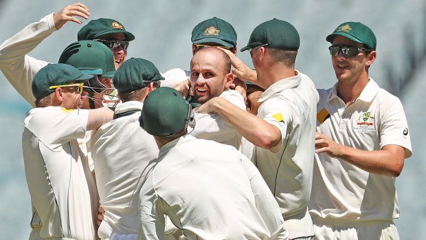 Man in the middle: Nathan Lyon is congratulated after dismissing Asad Shafiq. 