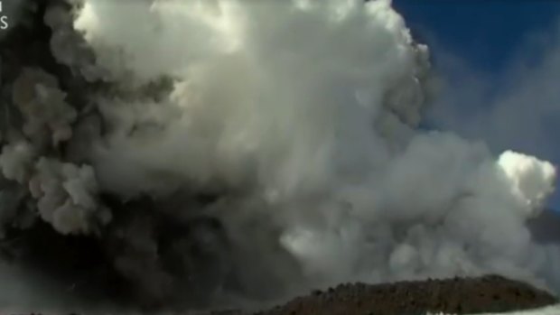 A huge cloud mushrooms over Mount Etna after it erupts.