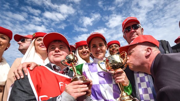 Stevie Payne, left, with sister Michelle, trainer Darren Weir and one of the owners kissing the cup.