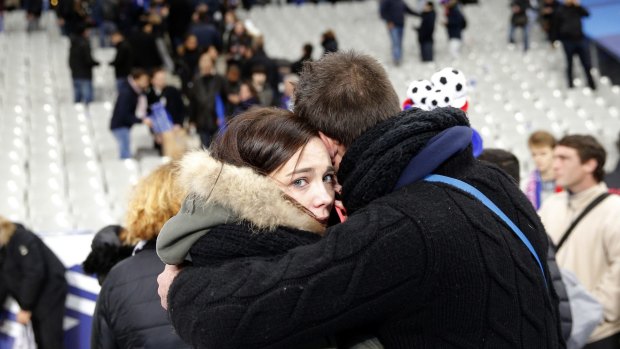 A supporter conforts a friend at the Stade de France stadium.