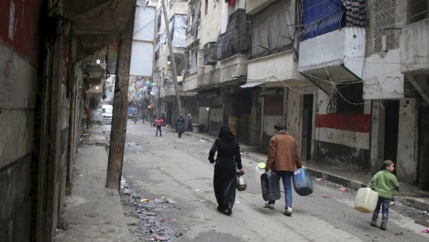 Civilians walk with containers for fuel and water in Aleppo, Syria in this photo from February, 2016.