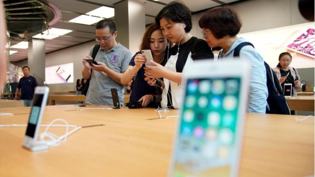 Customers look at an IPhone 8 Plus at an Apple Store in Shanghai, China.