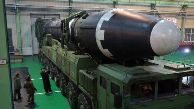 North Korean leader Kim Jong-un, third from left, and what the North Korean government calls the Hwasong-15 intercontinental ballistic missile.