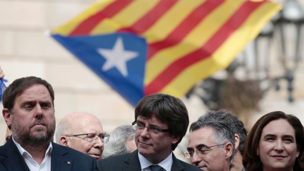 From left: Catalan regional Vice-President Oriol Junqueras, Catalan President Carles Puigdemont and Barcelona's mayor Ada Colau stand outside during a protest called by pro-independence at the Palau Generalitat in Barcelona.