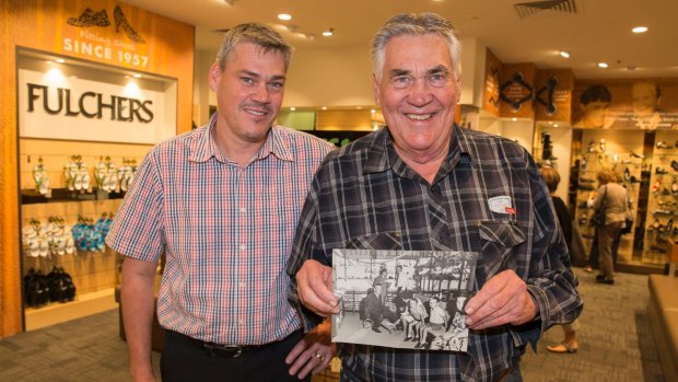 Troy (left) and Trevor (right) at Fulchers Shoes, holding a picture of Trevor's father, Gordon, at work.