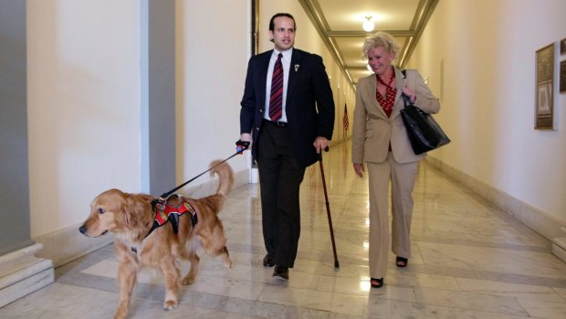 Iraq War veteran Luis Carlos Montalvan and his service dog walk at Capitol Hill in Washington.