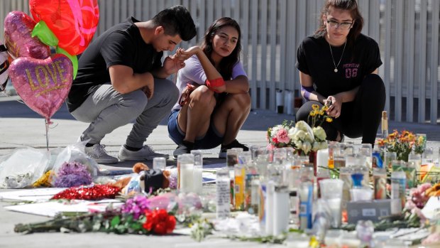 Roberto Lopez, from left, Briana Calderon and Cynthia Olvera, of Las Vegas, pause at a memorial site in Las Vegas.