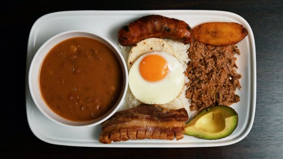 Bandeja paisa platter with braised red beans, chicharron (fried pork belly), minced beef, Colombian chorizo,  plantain, avocado, arepa, fried egg and rice.