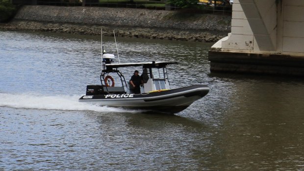 Water police search the Brisbane River around the William Jolly Bridge.