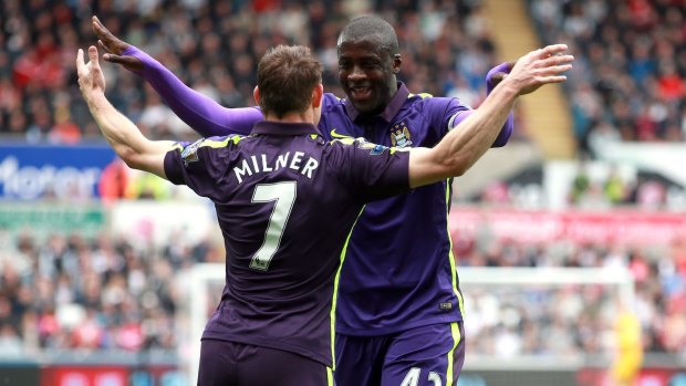 Manchester City's Yaya Toure, right, celebrates scoring his side's first goal with James Milner.