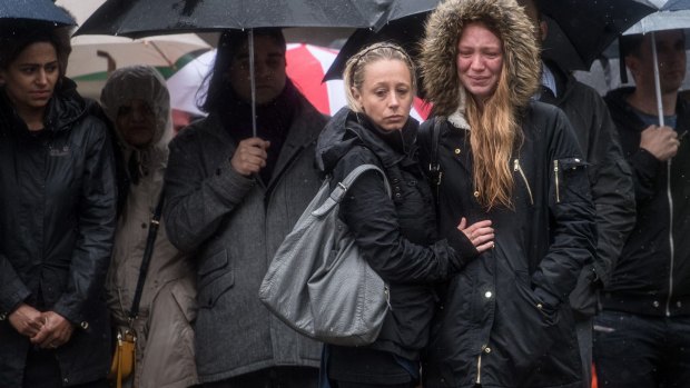 A woman is comforted by her friend as she breaks down in tears after a minutes silence near the scene of Saturday's terrorist attack in London, England. 