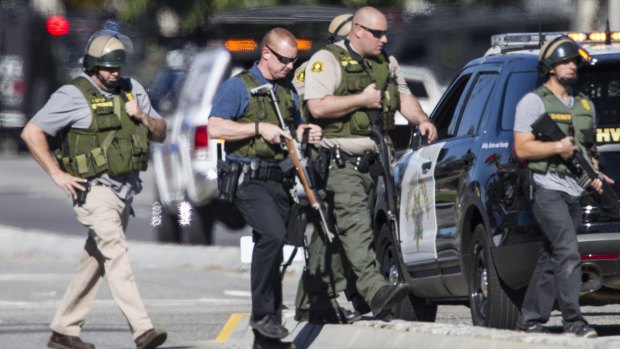 San Bernardino police officers in SWAT gear secure the scene of a mass shooting.