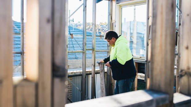 Labourer George Nanos working on an unfinished home in Casey. 
