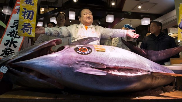 Kiyomura president Kiyoshi Kimura poses with a fresh bluefin tuna after the year's first auction at Tsukiji Market in Tokyo, Japan. 