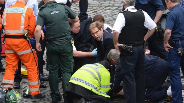 British MP Tobias Ellwood, centre, helps paramedics try to revive the stabbed officer.