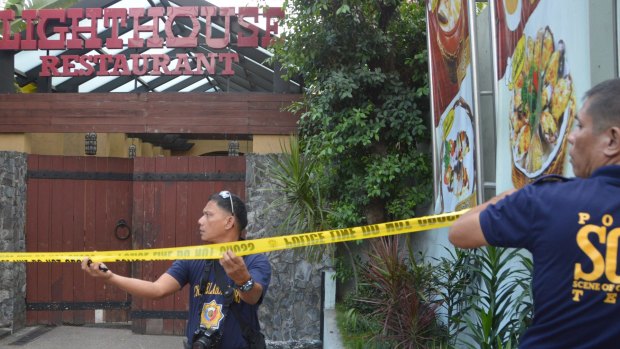 Police mark the crime scene with a yellow tape after two Chinese diplomats were killed in Cebu province, central Philippines.