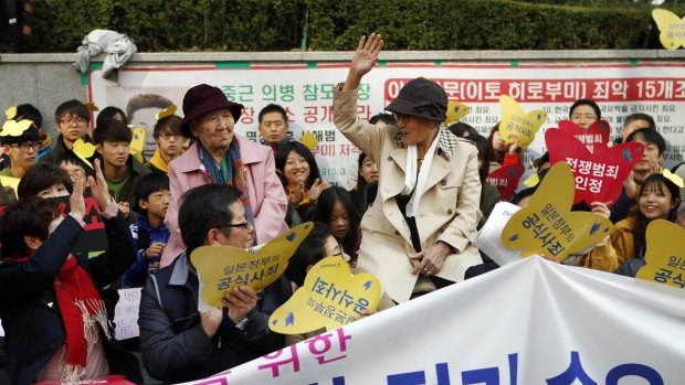 Kim Bok-dong (hand raised), who was pressed into sex slavery by the Japanese army, greets the weekly "Wednesday protest" which has been running for 23 years at Japan's embassy in Seoul.