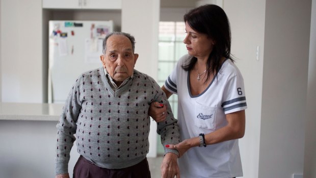 Domenica Vevile helping her father Giovanni, who needs care at home.