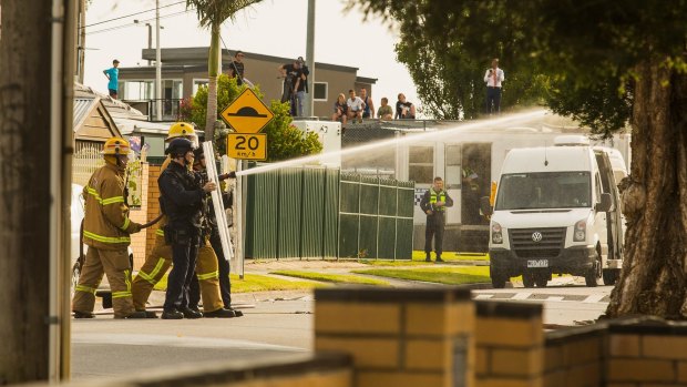 Emergency services workers sprayed high-pressured water during the siege.