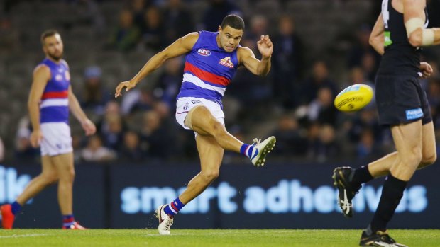 Painful: Jason Johannisen of the Bulldogs kicks, only to end up injuring his hamstring.