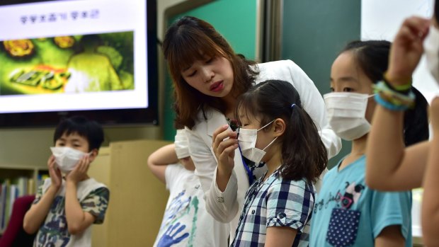 South Korean school students put on face masks during a class on MERS in Seoul.