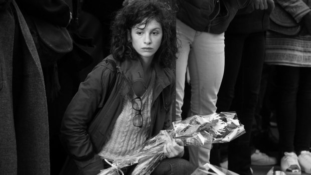 A woman in Paris places flowers in memory of terror attack victims.