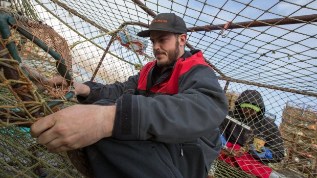 Unafraid to get his hands dirty, Brenna A Captain Sean Dwyer helps his crew rig pots. 