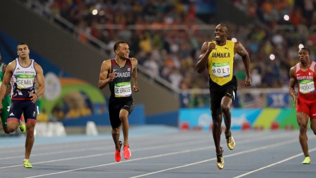 De Grasse looks at Bolt as he gains on the Jamaican sprinter.