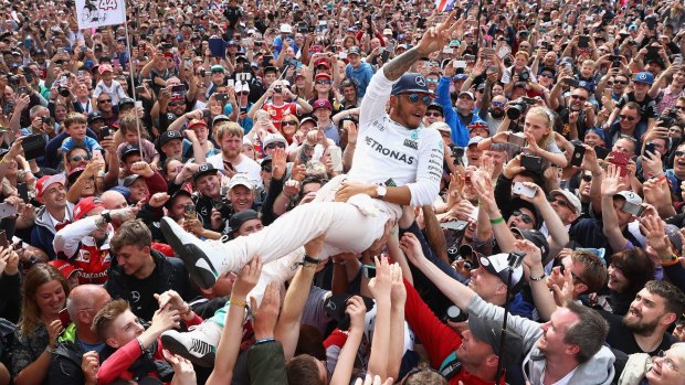 Hamilton surfs the crowd after his win.