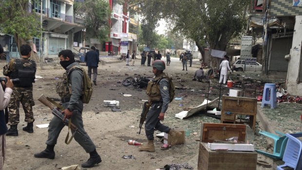Afghan security forces inspect the site of a suicide attack near a new Kabul Bank in Jalalabad.