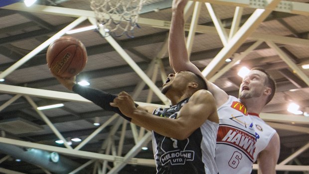 Melbourne United's Stephen Holt is fouled by A.J. Ogilvy of the Illawarra Hawks.