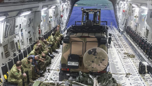 Members of Australia's reconnaisance and assessment team prepare to disembark a RAAF C-17A Globemaster aircraft at the Nausori International Airport in  Fiji.