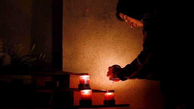 A man lights a candle to place beneath a shrine on the hill leading up to Laferla Cross outside the village of Siggiewi, Malta, on Thursday. Several Easter processions take place around Malta between Maundy Thursday and Easter Sunday, drawing thousands of visitors.  