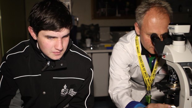 Year 9 student and Camp Director Mitch Cartwright analyses some forensic evidence together with lab manager Gordon Mclennan.