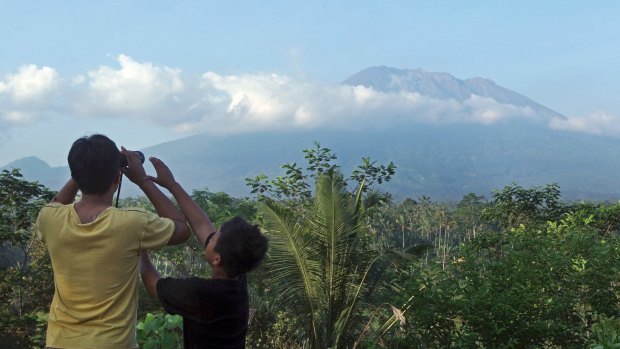 A man observes the Mount Agung with binoculars at a viewing point last week, as fears began to mount of an eruption.
