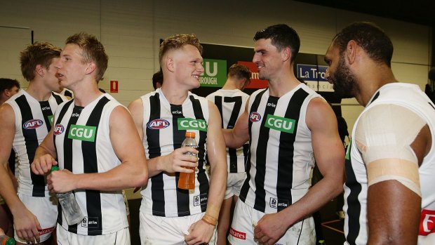 Winners are grinners: Adam Treloar (centre) of the Magpies and teammate Scott Pendlebury smile after beating the Giants. 