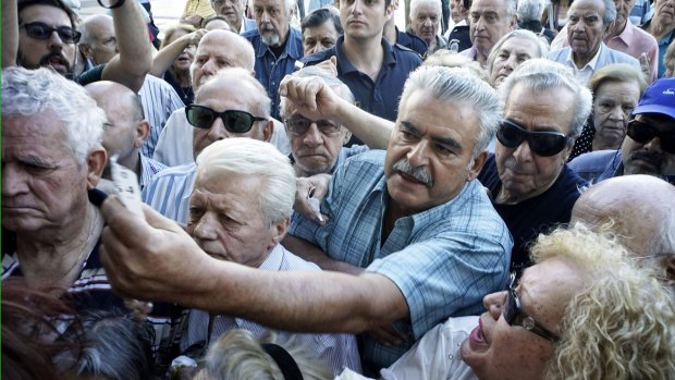 Pensioners jostle outside an Athens bank on Wednesday.