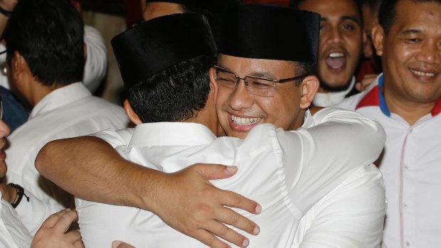 Jakarta's governor-elect Anies Baswedan, right, hugs his running mate  as unofficial results showed him defeating Ahok on April 19.