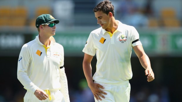 Steve Smith talks to Mitchell Starc as the left-arm paceman walks back to his bowling mark.