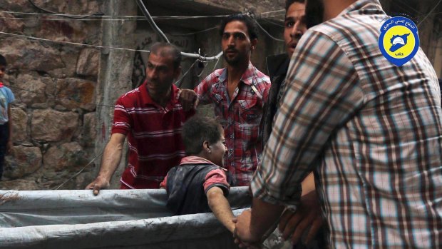 Workers take out a boy, alive, from the rubble, in Aleppo, Syria.