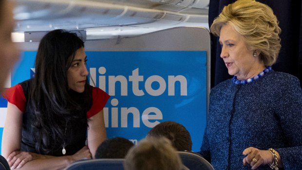 Hillary Clinton speaks with Huma Abedin aboard the campaign plane to Iowa on Friday.