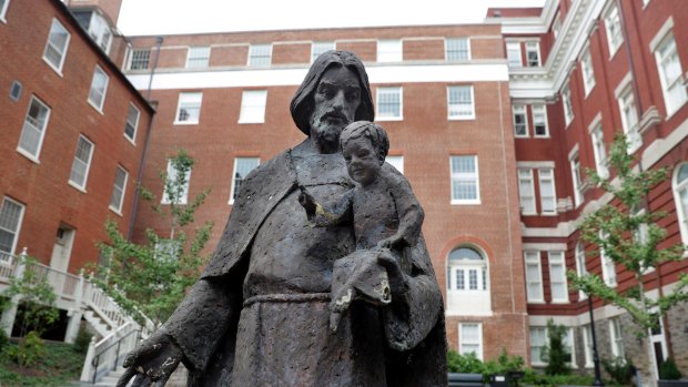 A Jesuit statue is seen in front of Freedom Hall, formerly named Mulledy Hall, on the Georgetown University campus, Thursday.