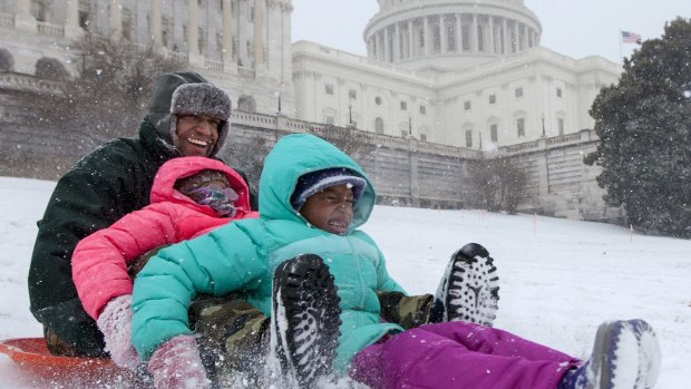Bashon Mann and his children sled down a hill on Capitol Hill in Washington as snow falls. With a major blizzard threatens to dump over 90 centimetres of snow on Washingon, DC.