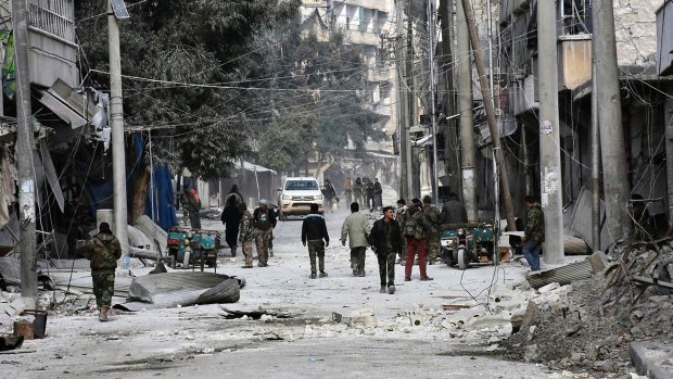 Syrian soldiers and civilians marching through the streets of east Aleppo, Syria.