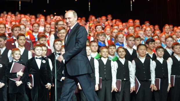 Russian President Vladimir Putin walks in front of a children's choir before the choir gave a concert in the Kremlin Palace in Moscow on Christmas Day. 